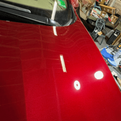 Red exterior auto finish after coating and detailing showing a showroom shine and polished finish.