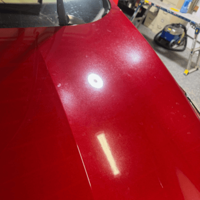 Red exterior auto finish before coating and detailing showing dull finish.